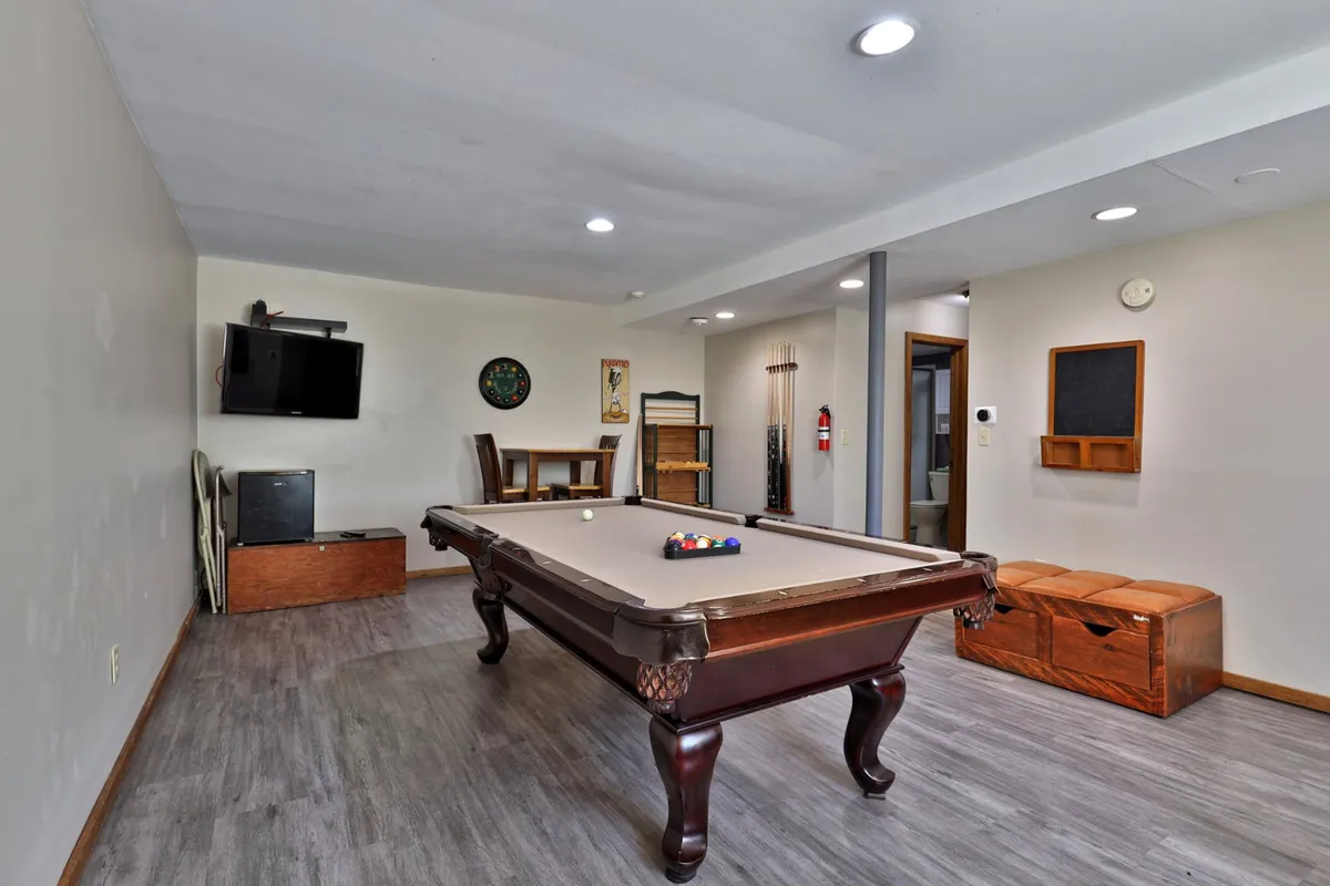 The interior image spotlights a lively social space with a pool table, television, dining table, and wall art, all set in a friendly, relaxed atmosphere. It suggests opportunities for game nights, streaming favorite shows, or simply unwinding after a day on the slopes.