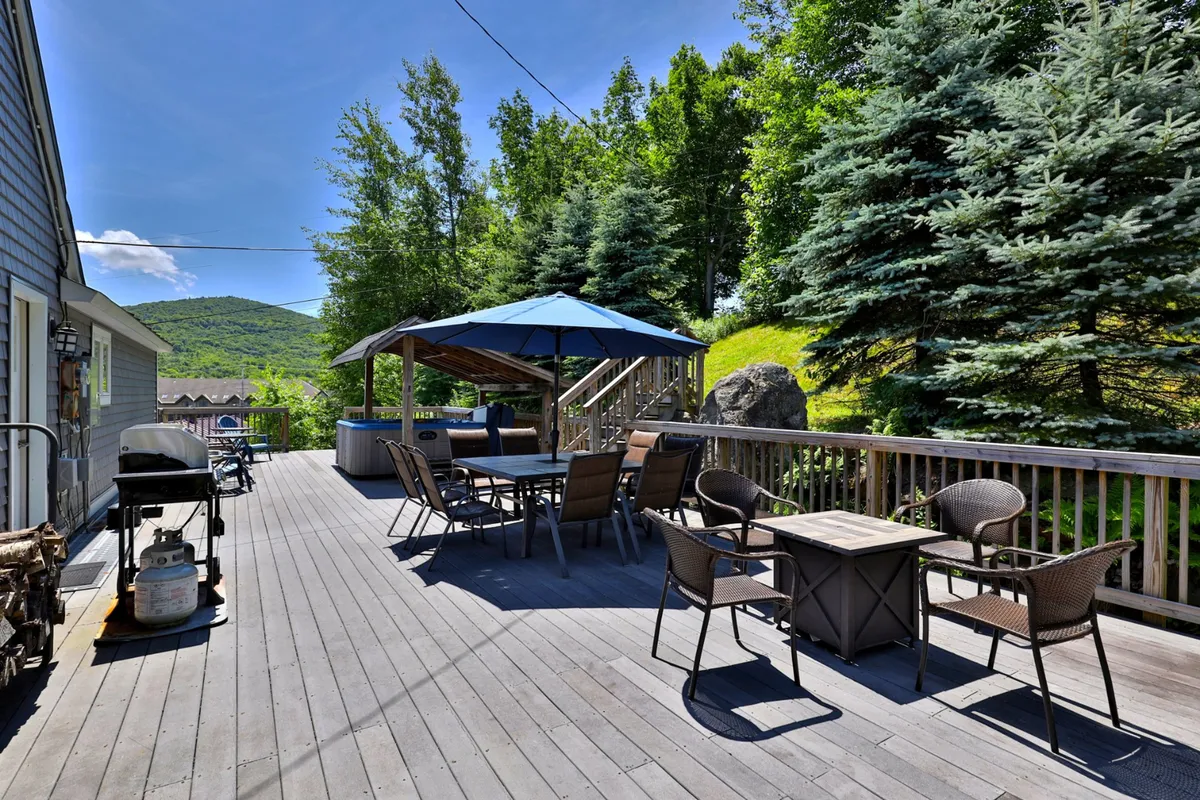 A relaxed outdoor seating area with a gazebo, grill, and surrounding trees, ideal for family barbecues, outdoor dining, and relaxation. The inviting setup encourages families to gather outside for meals or to unwind after a day exploring nearby trails or attractions.